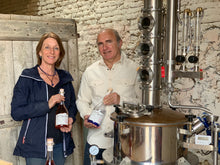 Charger l&#39;image dans la galerie, Let yourself be guided by our WSET Spirits diploma-qualified producer and exchange with our founders around a glass (or three) of gin. Pictured are Anne and Jean-Louis in their gin distillery, holding their Original gin and Rosé Gin. French: Laissez-vous guider par notre productrice diplômée WSET spiritueux et échangez avec nos fondateurs autour d’un verre (ou trois) de gin. Sur la photo sont Anne et Jean-Louis dans leur distillerie de gin, tenant leur Gin Original et Gin Rosé.
