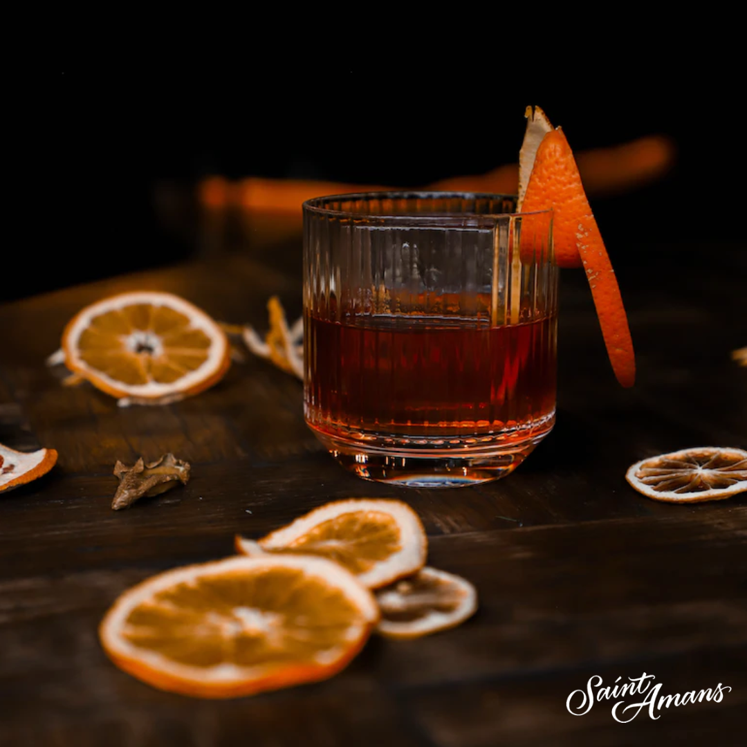 Our gorgeous Negroni cocktail made of our handcrafted, natural gin from the South West of France., presented here on a beautiful table laid with orange zests to match the orange peel on the glass, the perfect addition to our Negroni. Notre sublime Negroni fabriqué à base de notre gin naturel artisanal du sud-ouest de la France, ici présenté sur une jolie table recouverte de zestes d’orange assortis à l’écorce d’orange sur le verre, l’addition parfaite pour notre Negroni.